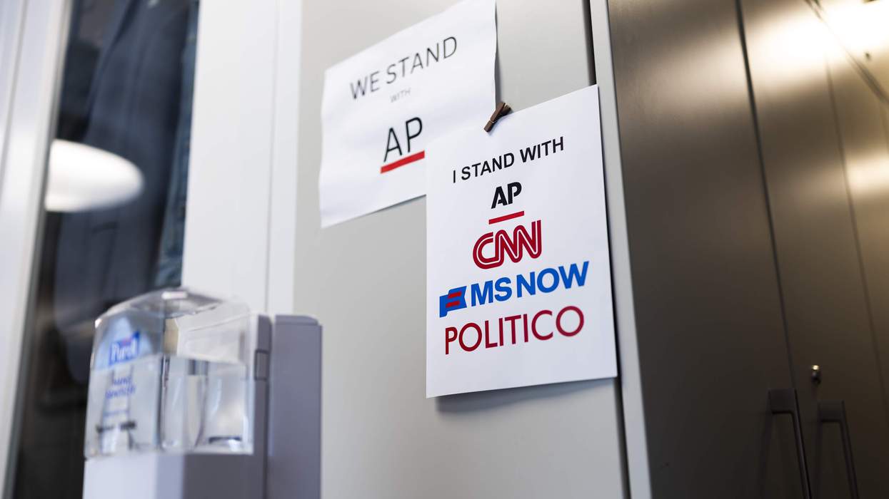 Signs of support for AP, CNN, MS NOW and POLITICO hang on an inside wall of the White House.