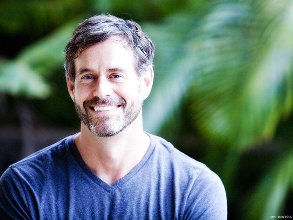 smiling bearded man blue vneck shirt