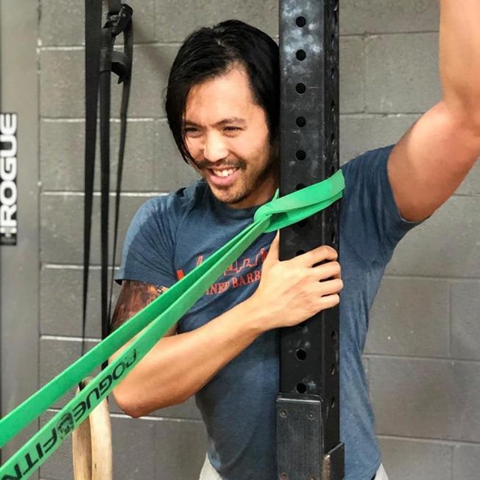 Stephan Wang stretching before a workout at his box, CrossFit Defined, in Chicago Illinois.