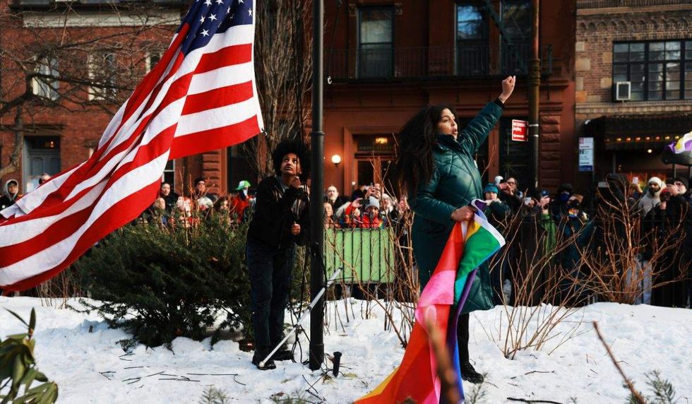 stonewall u.s. flag and pride flag being held by a community member
