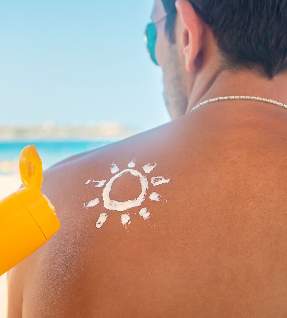 suntan lotion in the shape of sun on back shoulder beach scene