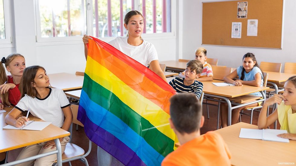 Teacher with students hold Pride flag