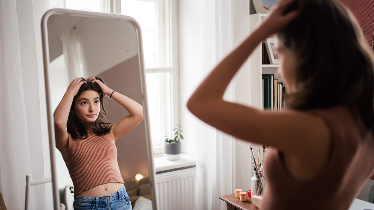 teenage girl looking in a mirror