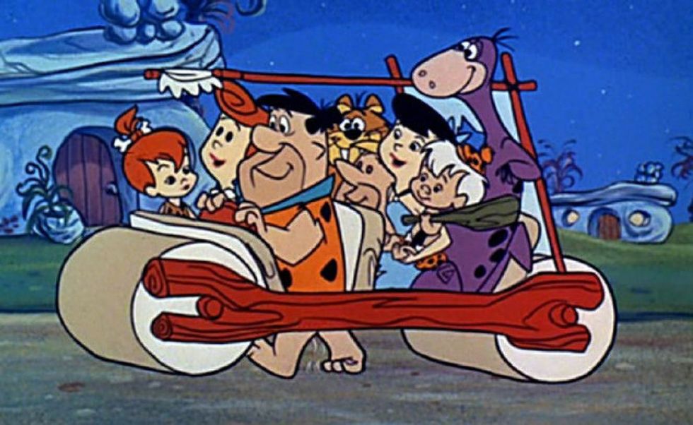 The Flintstones cartoon cast in Freds car