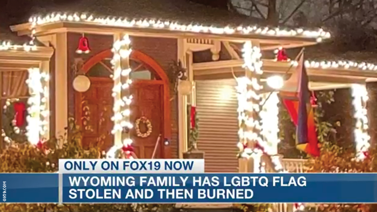 The front porch of a home with christmas lights and a pride flag