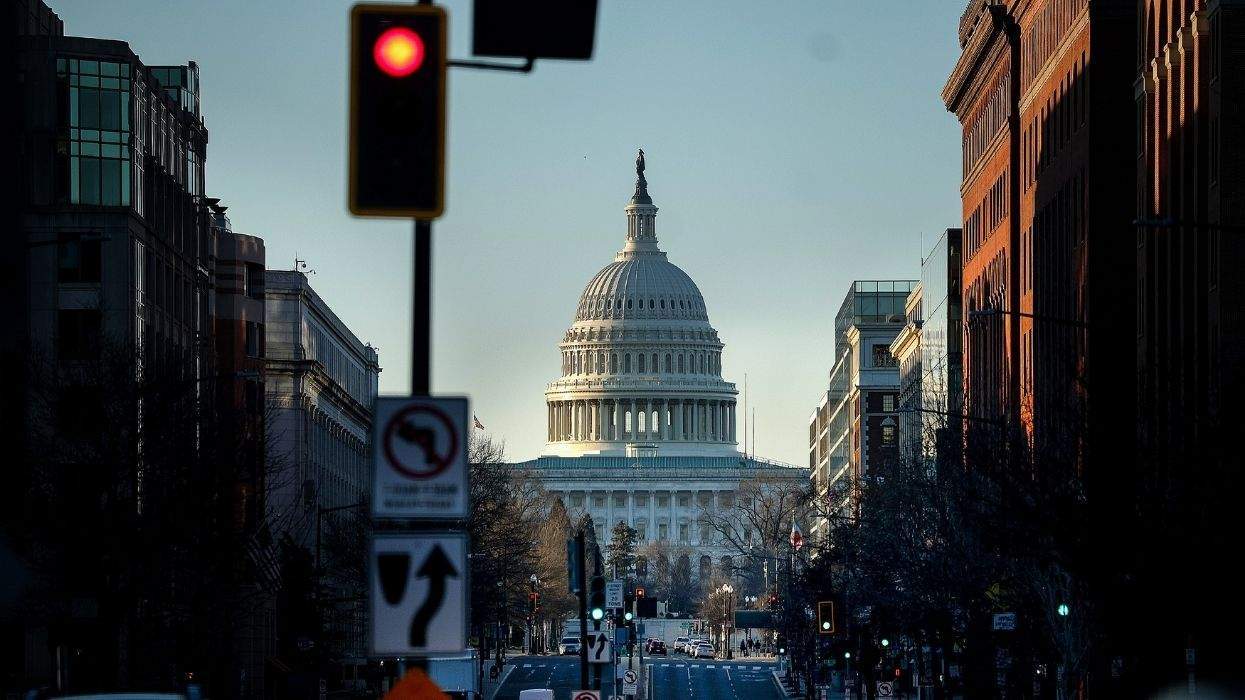the u.s. capitol with a red stoplight in the foreground