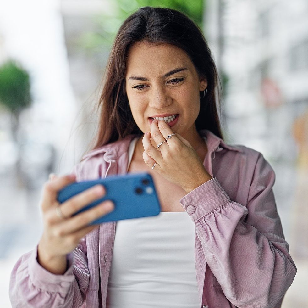 thoughtful woman watching cell phone video