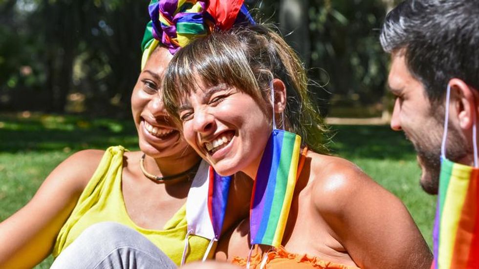 Three friends in rainbow attire laughing