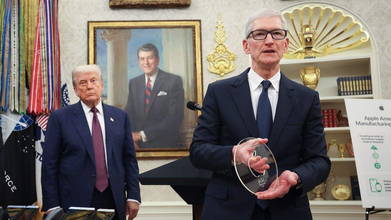 tim cook giving donald trump a class disc with the apple logo cut in it