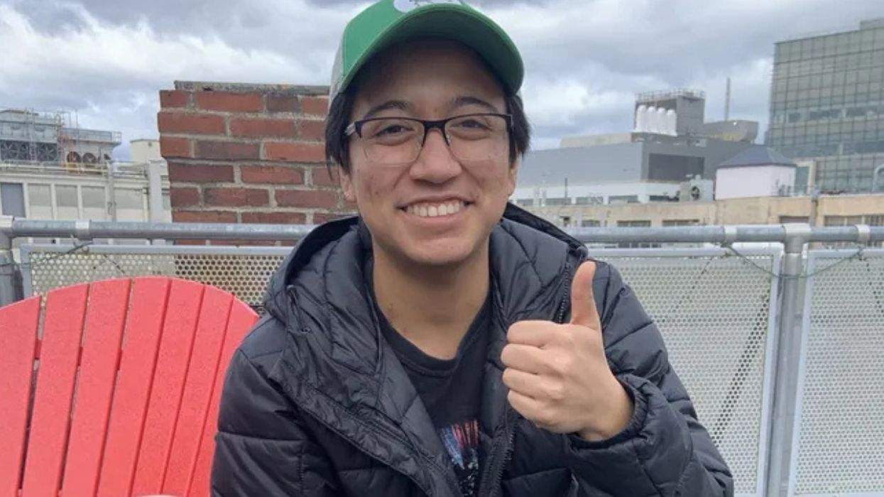transgender mit student wearing glasses and giving a thumbs up gesture