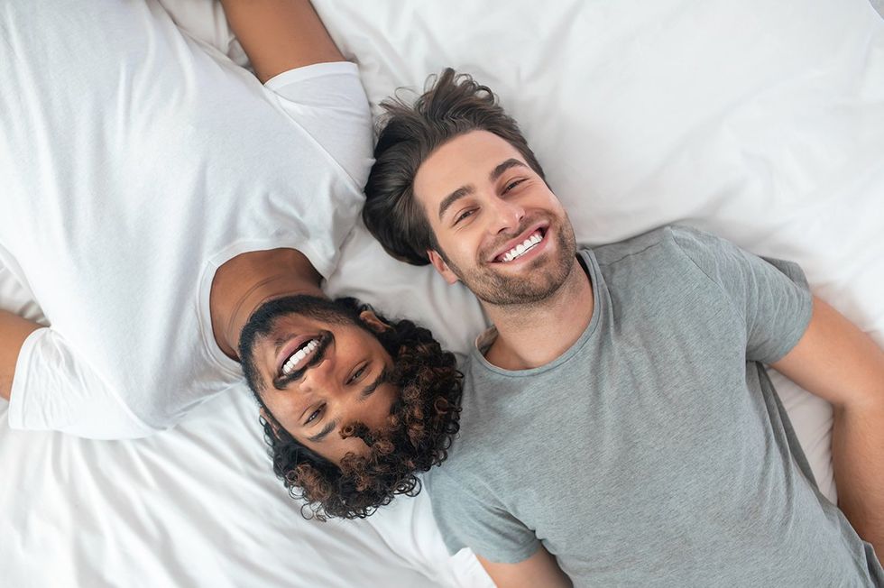 two happy guys from above on a white sheet