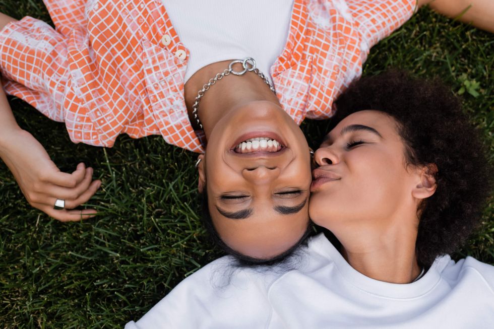 Two lesbians lying in the grass.