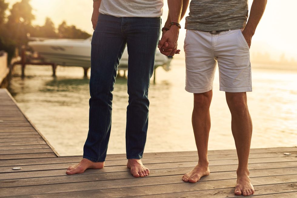 Two men holding hands while standing on a doc