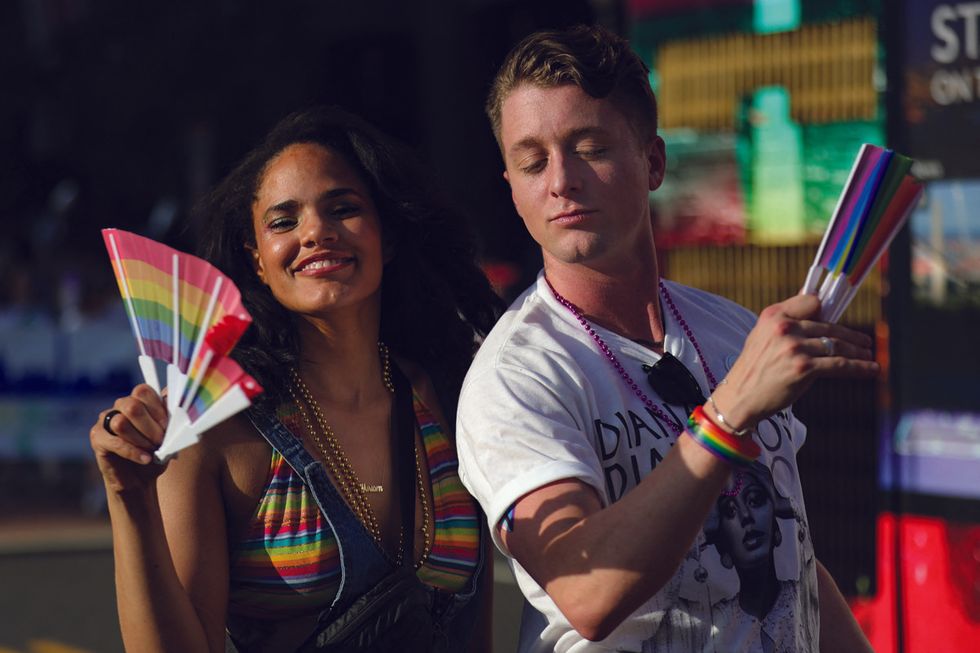 two people holding rainbow flags