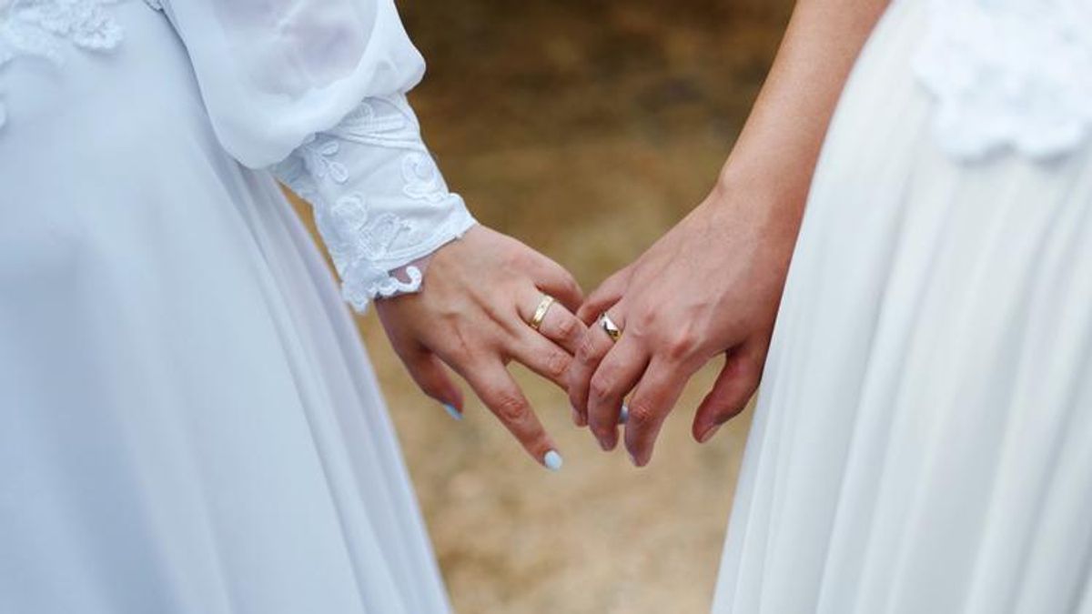 Two women on their wedding day with rings