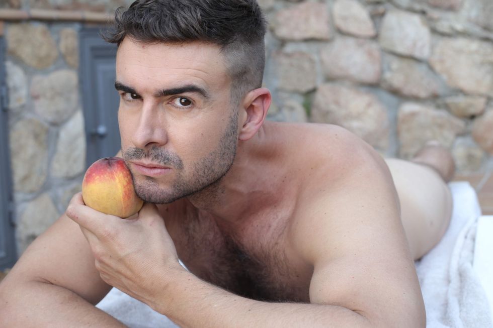 \u200bA man holding a peach.