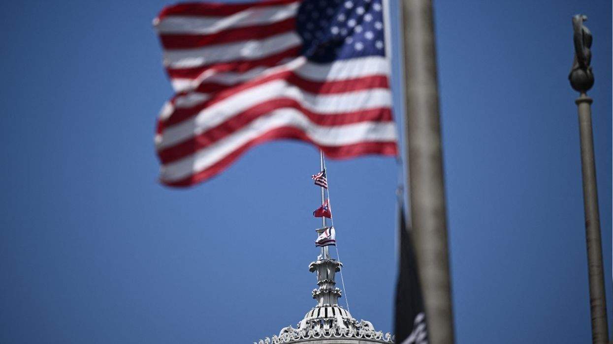 us flag and tennessee flag atop state capitol