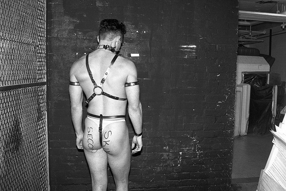 View of the inside of the Gay Community Center on 13th Street during a leather fetish festival. Note the men\u2019s bathroom on the right with old ceramic urinals (circa 1990).