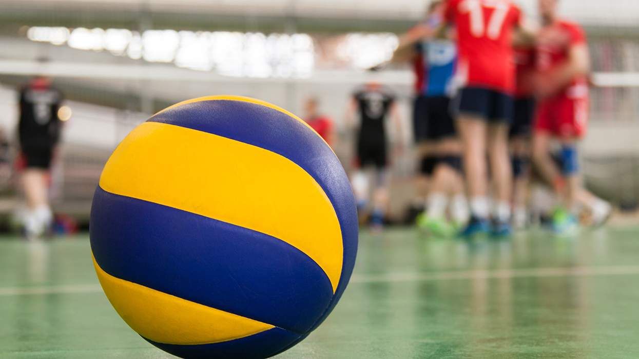 volleyball on court in gym with people in soft focus background