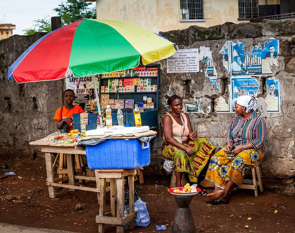 West Africa three unknown people at market Yongoro in front of the capital of the Sierra Leone Freetown