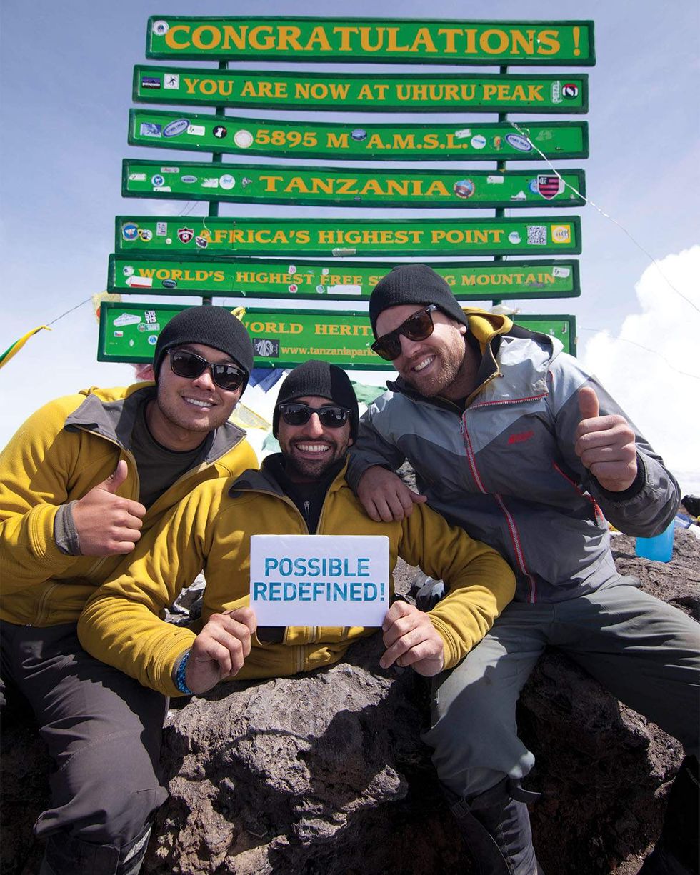 West and fellow climbers celebrate reaching the peak of Mount Kilimanjaro