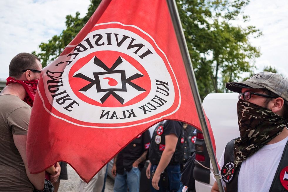 White supremacist racist organization Ku Klux Klan (KKK) members carrying invisible empire flag