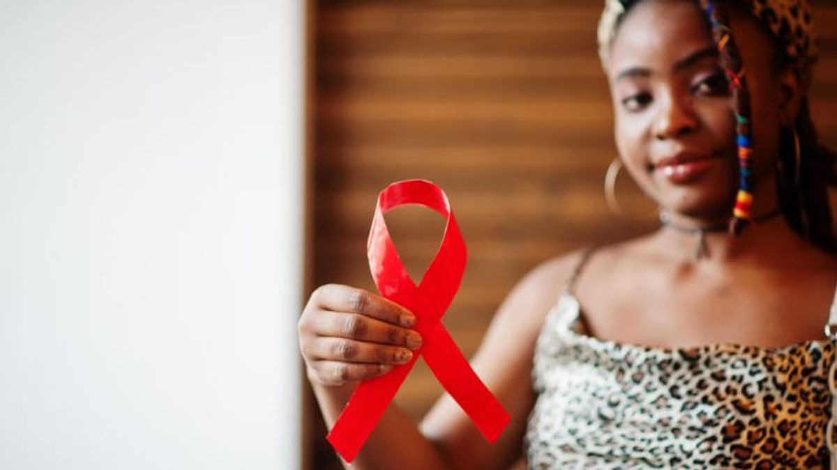 Woman holding AIDS awareness red ribbon