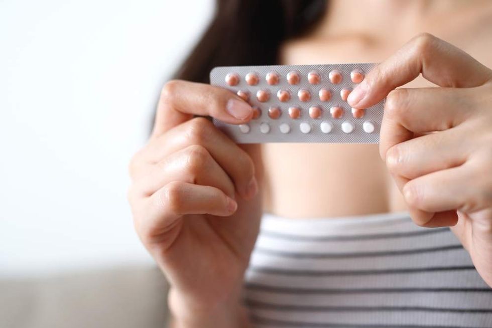 Woman holding birth control pills