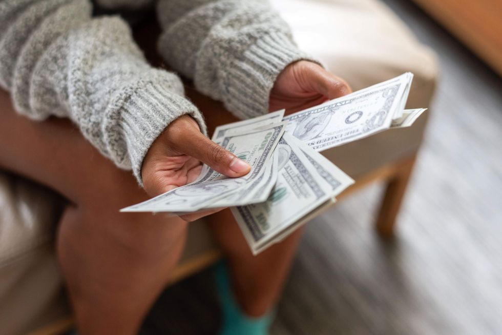 Woman holding money.