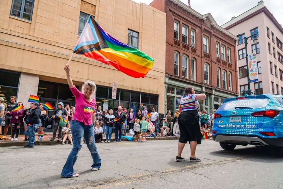 Woman waving flag at Pride in Portland, Maine