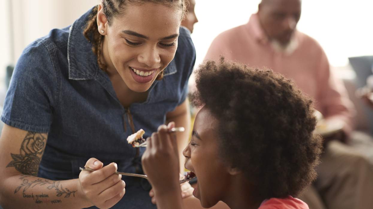 Woman with tattoos feeding a child pie
