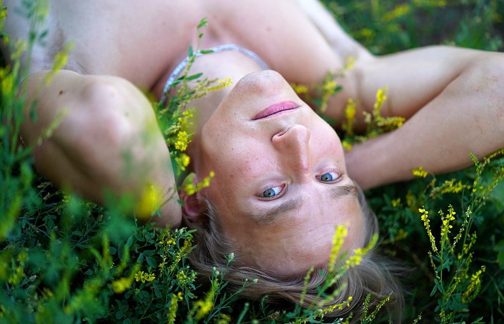 young blonde man shirless in the grass