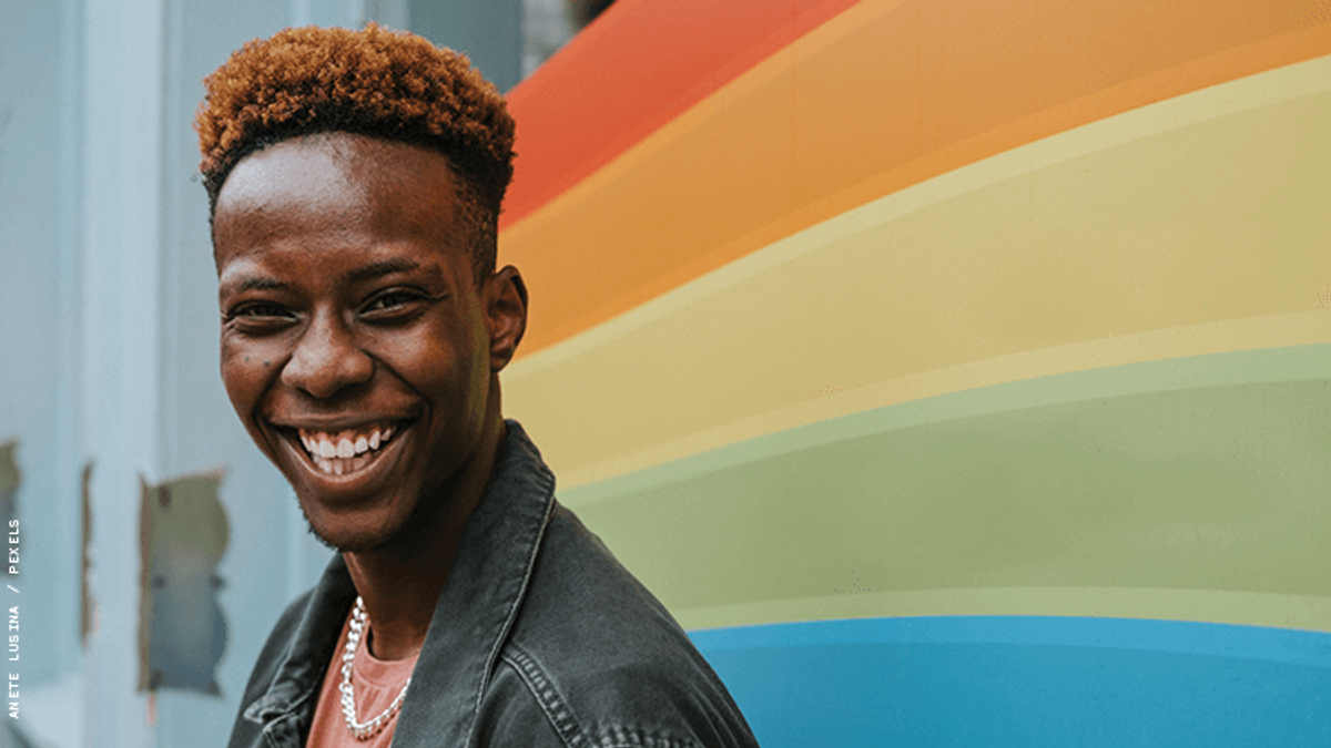 Young man in front of Pride flag