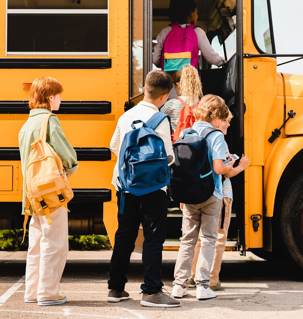 young queer person waiting in line to get on local school bus