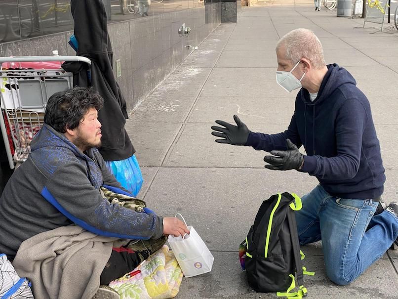 Jeffrey helping someone living on the streets of New York City