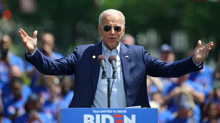Joe Biden in sunglasses with hands raised
