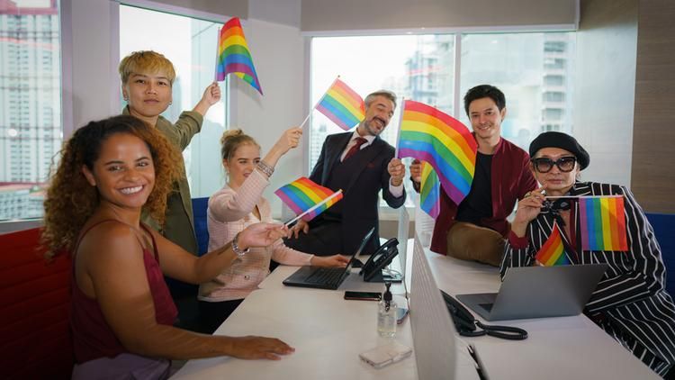 Group of employees holding pride flags