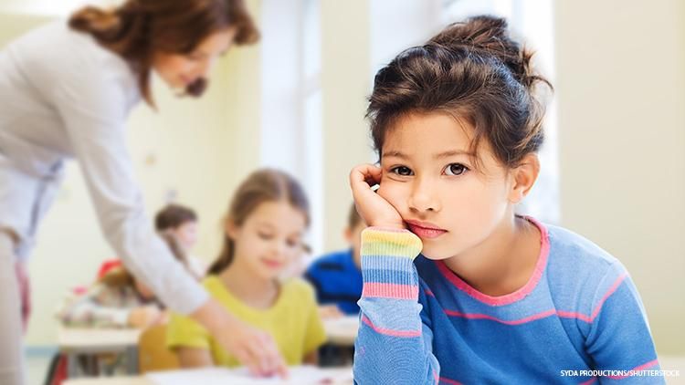 Child in a classroom looking sad