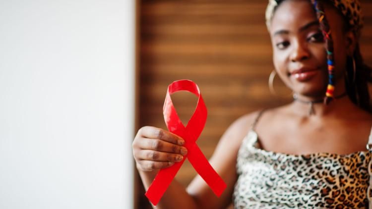 Woman holding AIDS awareness red ribbon