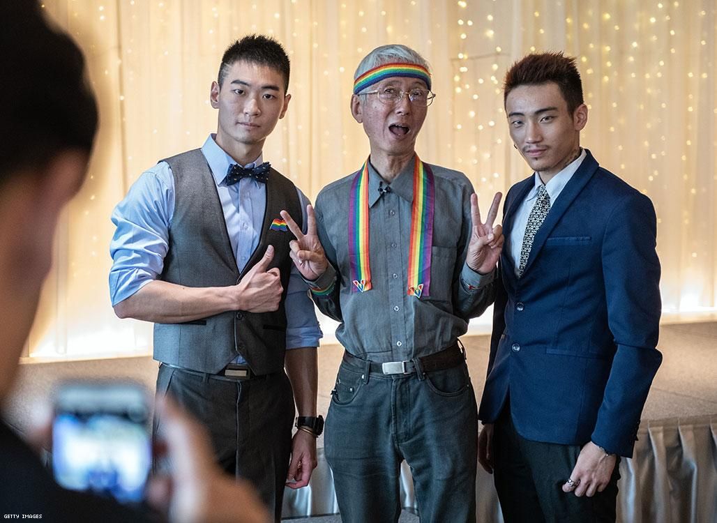Gay rights activist Chi Chia-wei (C) poses for a photograph with two gay men