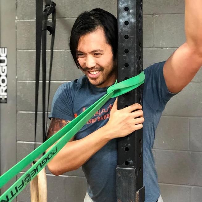 Stephan Wang stretching before a workout at his box, CrossFit Defined, in Chicago Illinois.