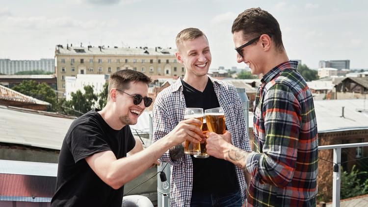 Three men cheering with beers