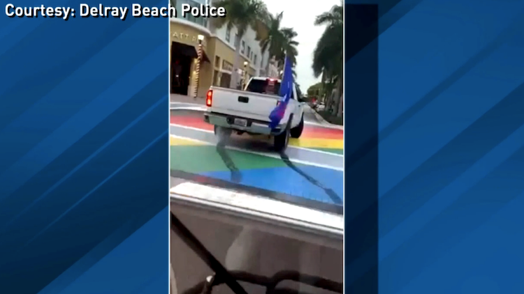 A truck doing a burnout over an LGBTQ-themed street painting